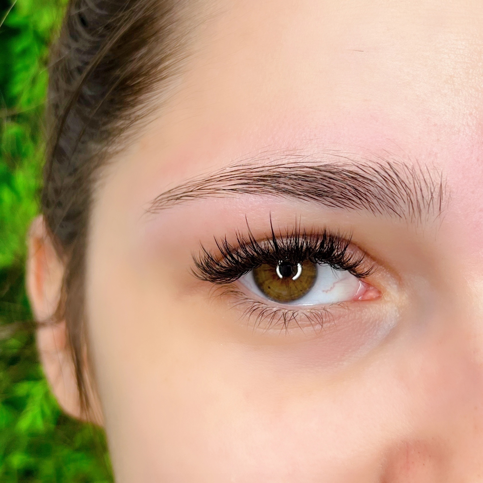 Close-up of a lifted, tinted lash and a laminated brow